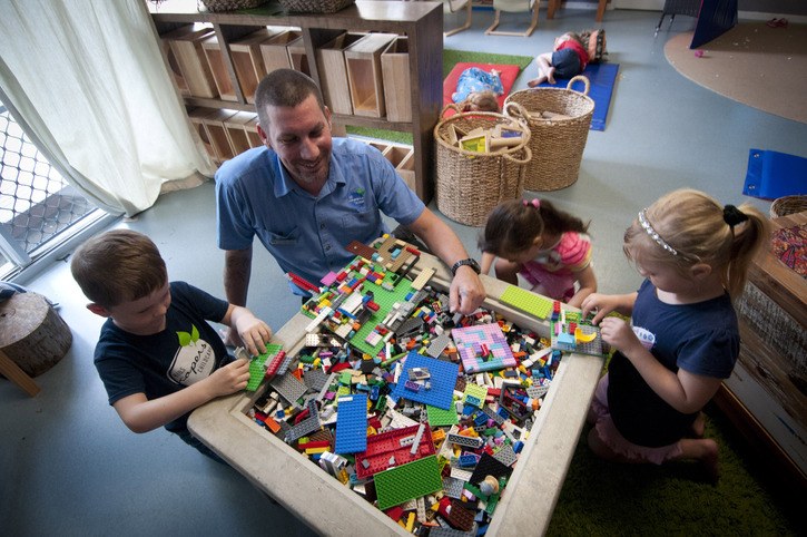 An adult playing a game with young children