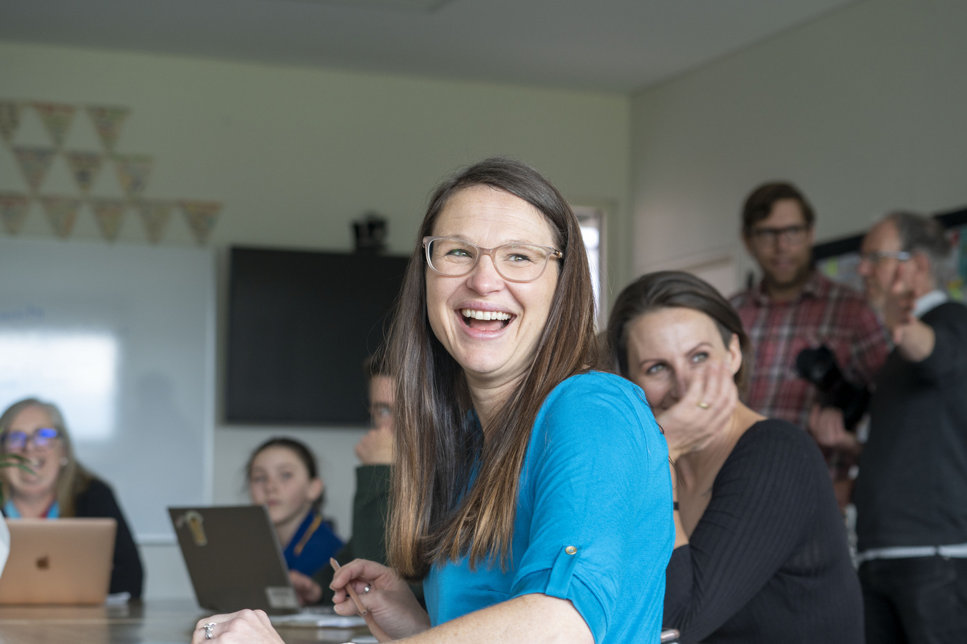 Educators in a classroom with children, laughing