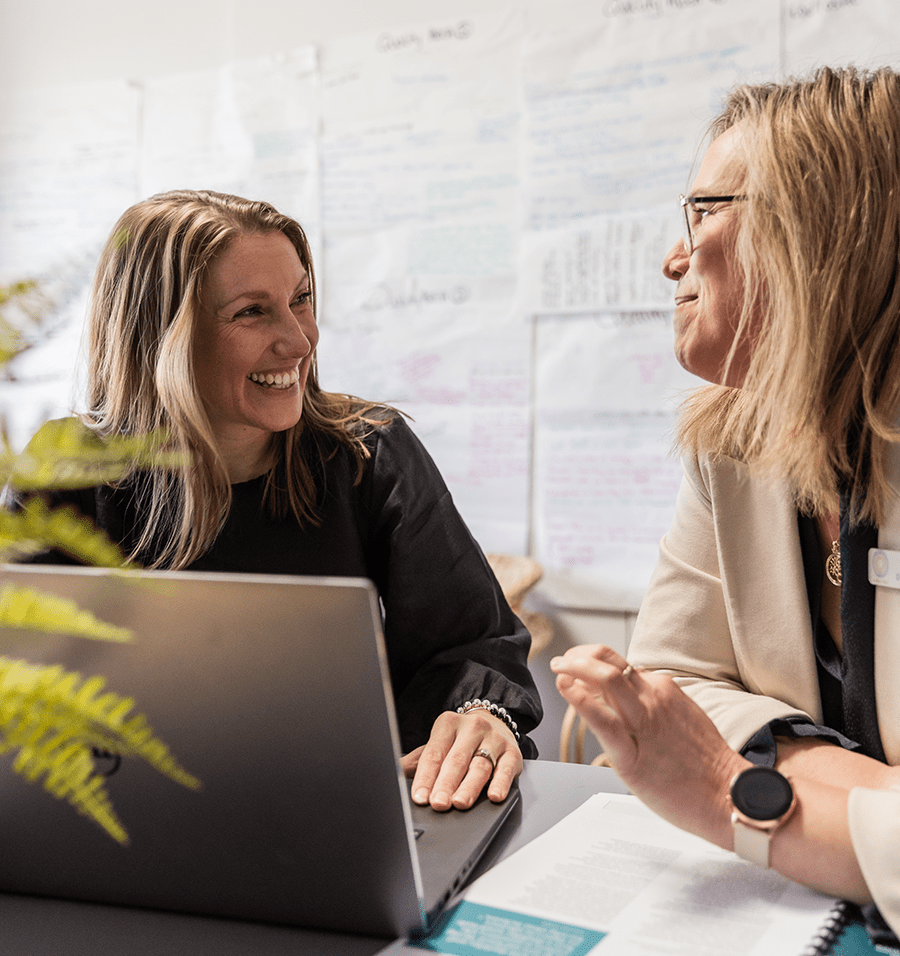 Image of educators talking and smiling within office.