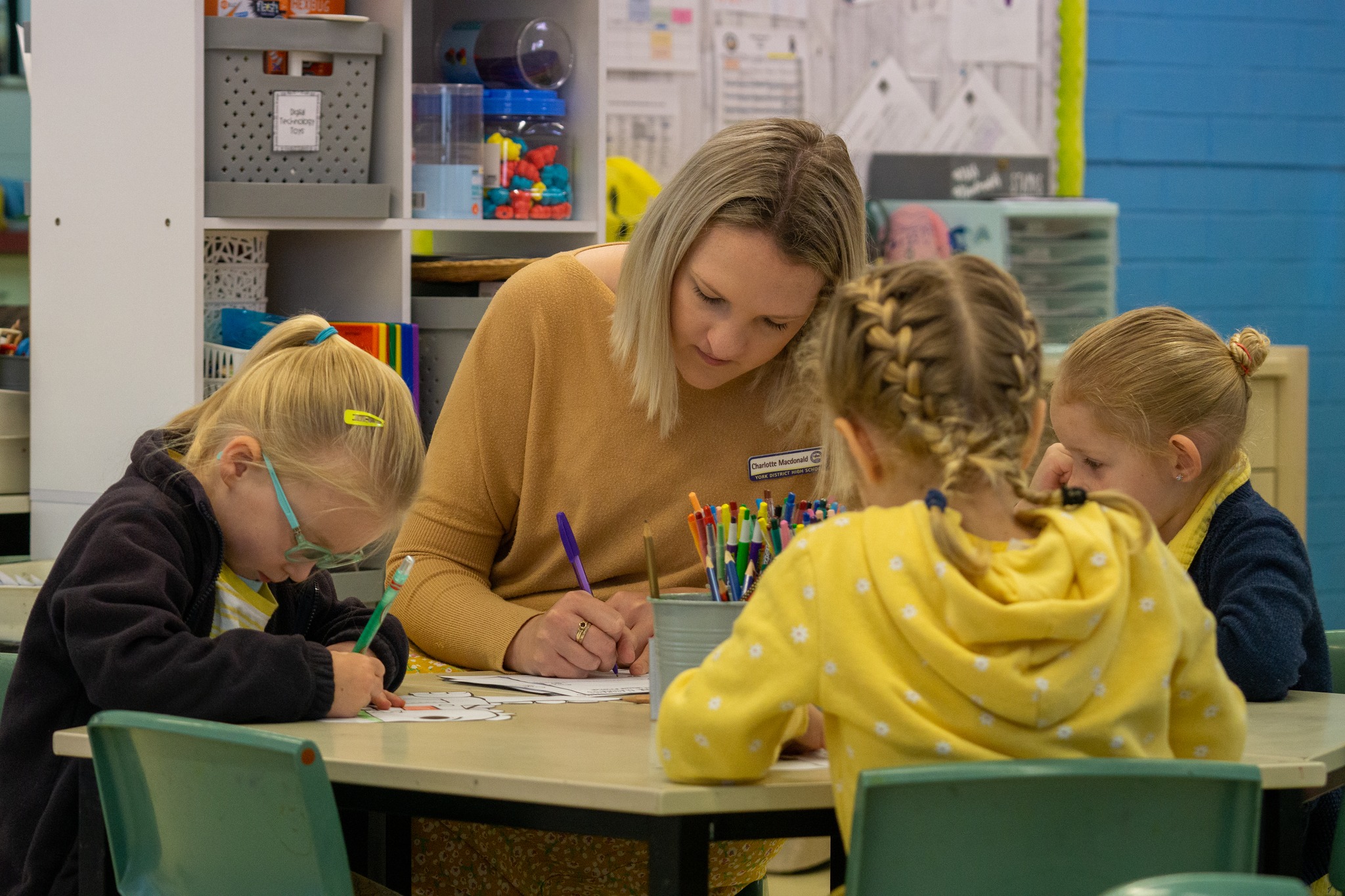 Charlotte works at a table with students at York District School