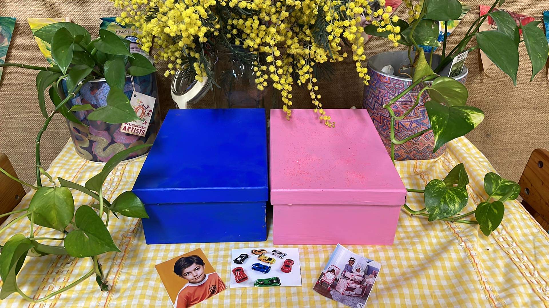 A blue and pink box sit on a table with photographs 