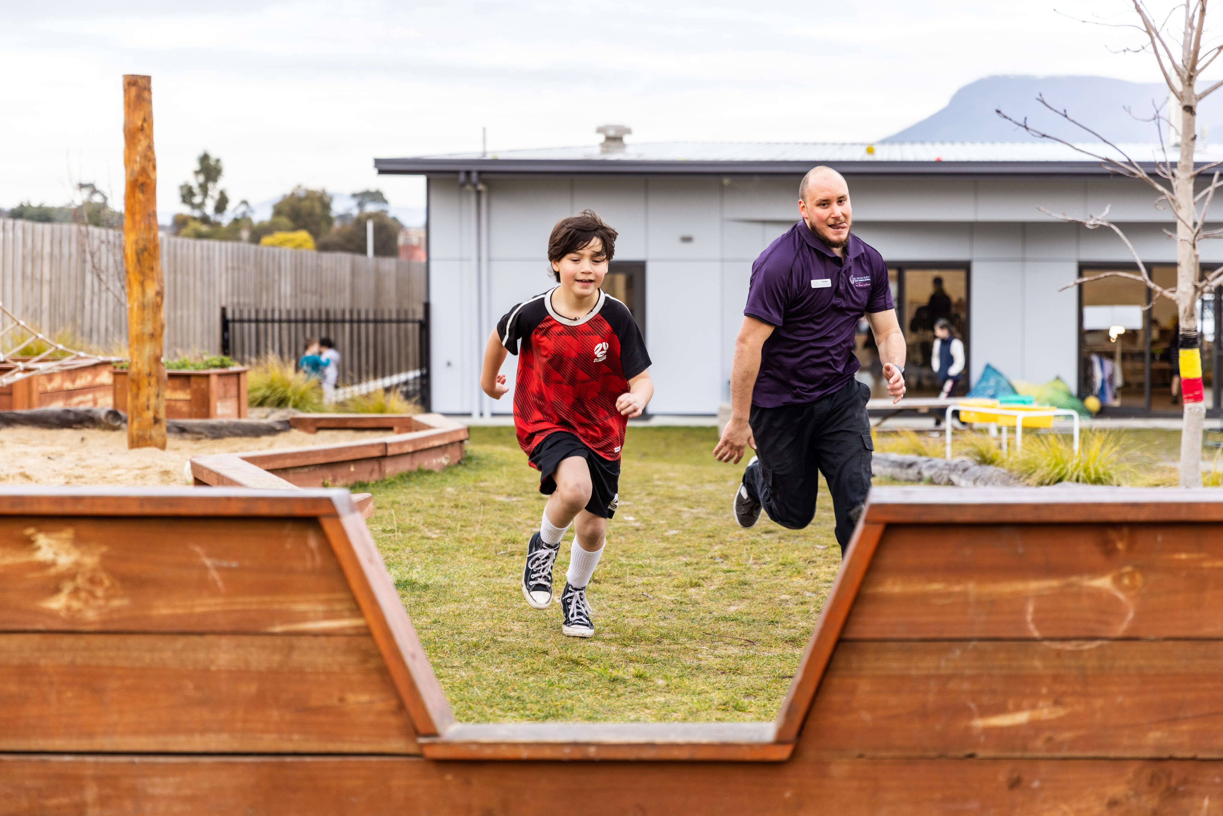 A child runs with an educator 