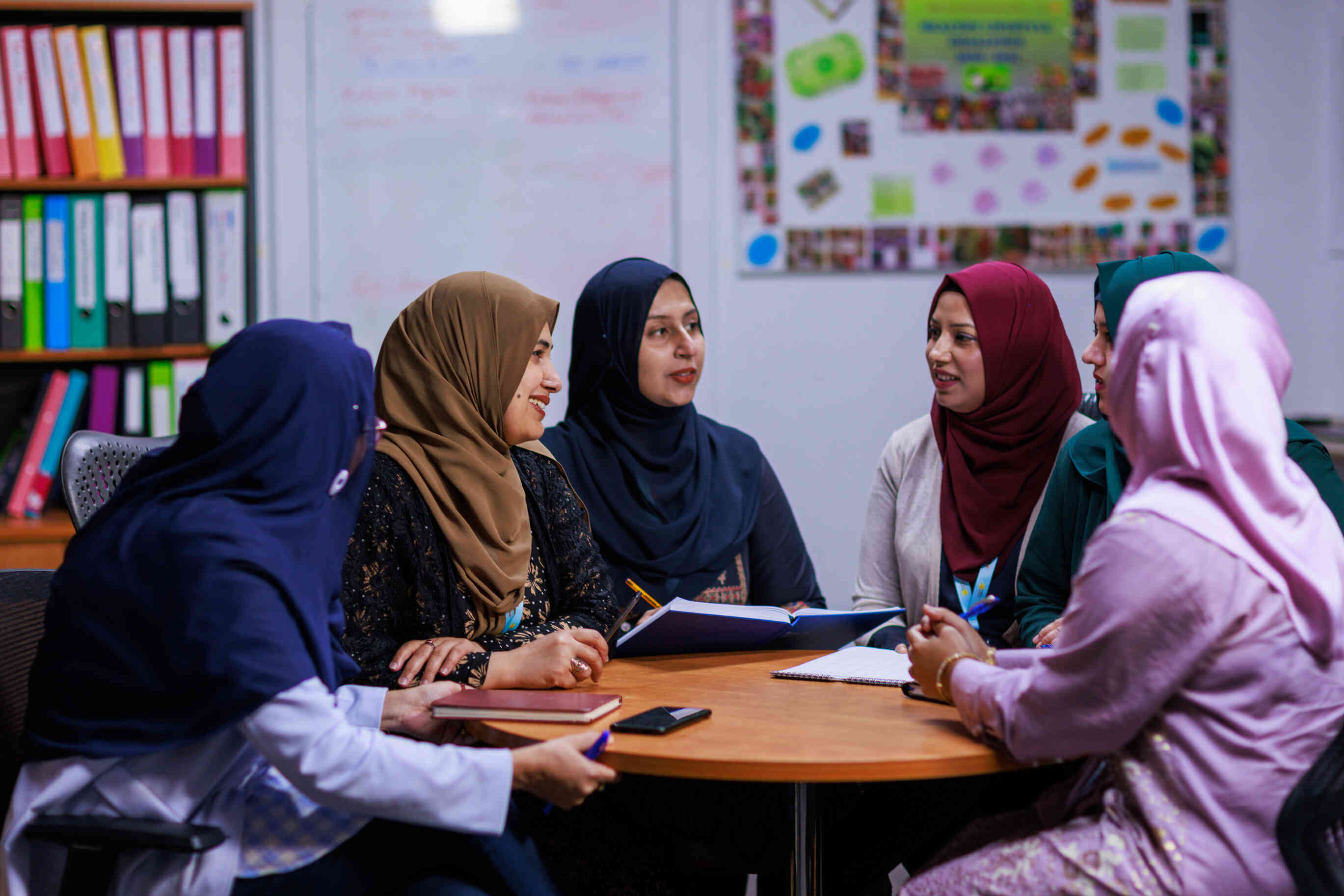 Educators sit around a table talking