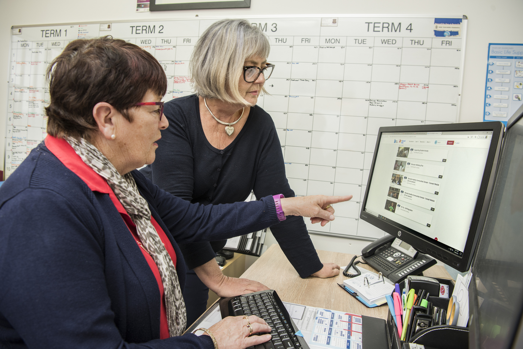 Two adults working at a computer