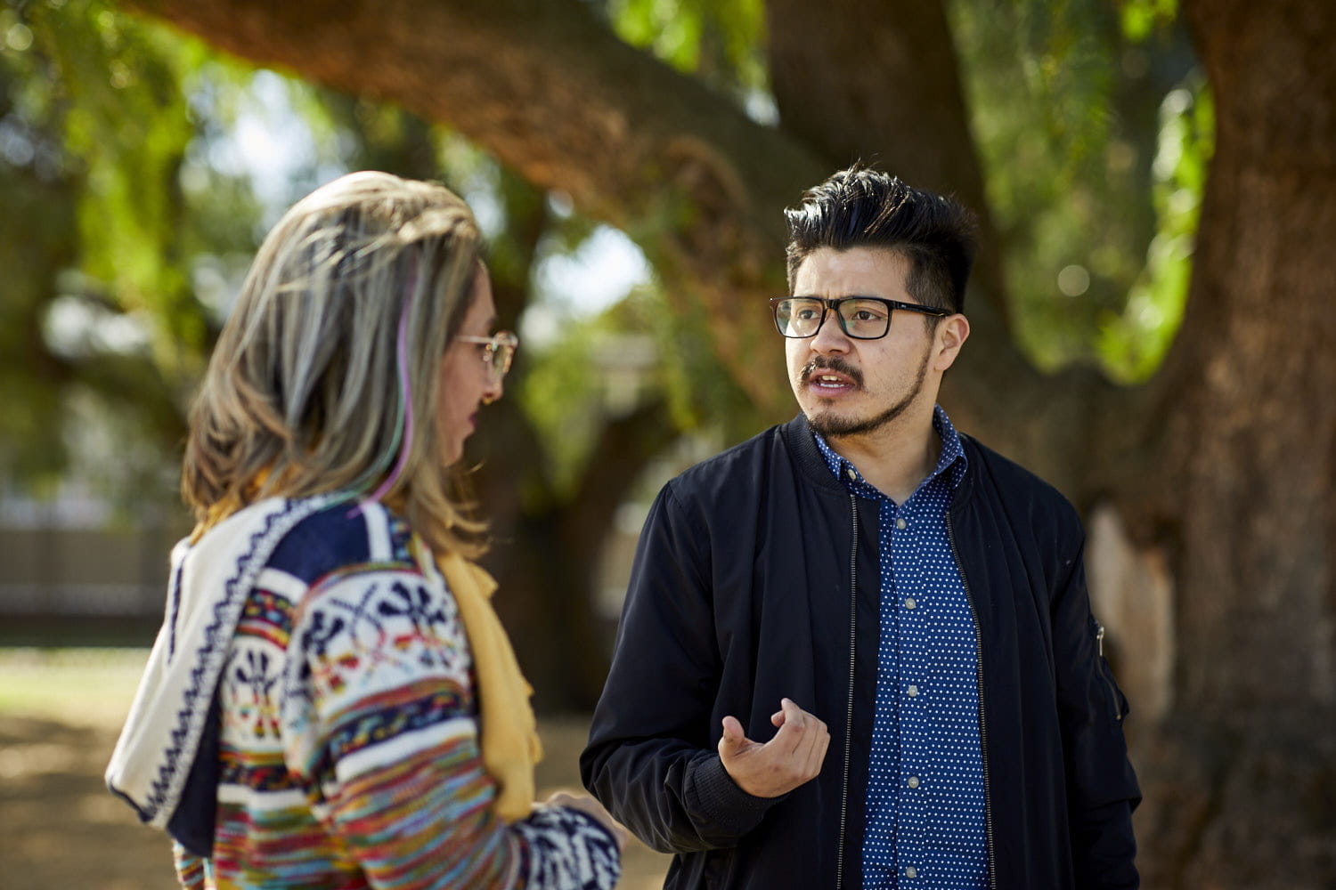 Two adults outdoors having a conversation.