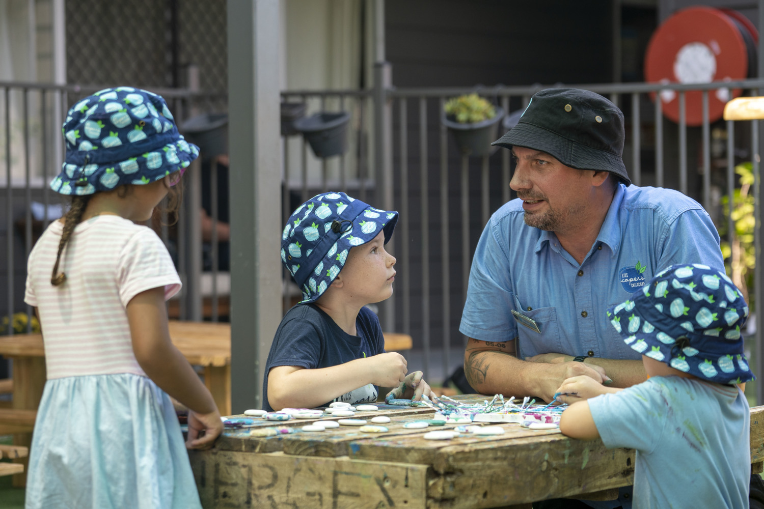 An educator and young children, sitting together