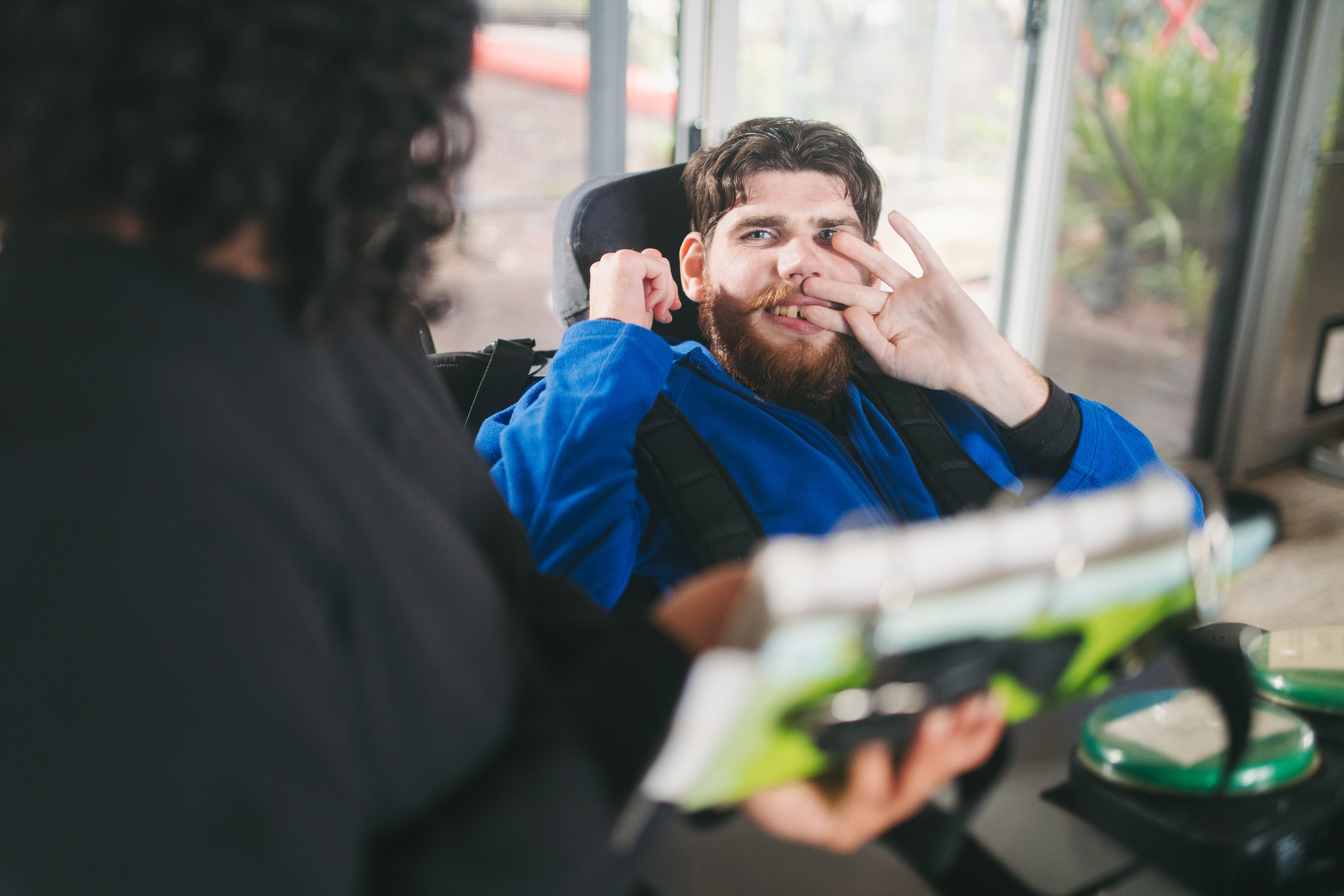A support staff member sitting with a young adult