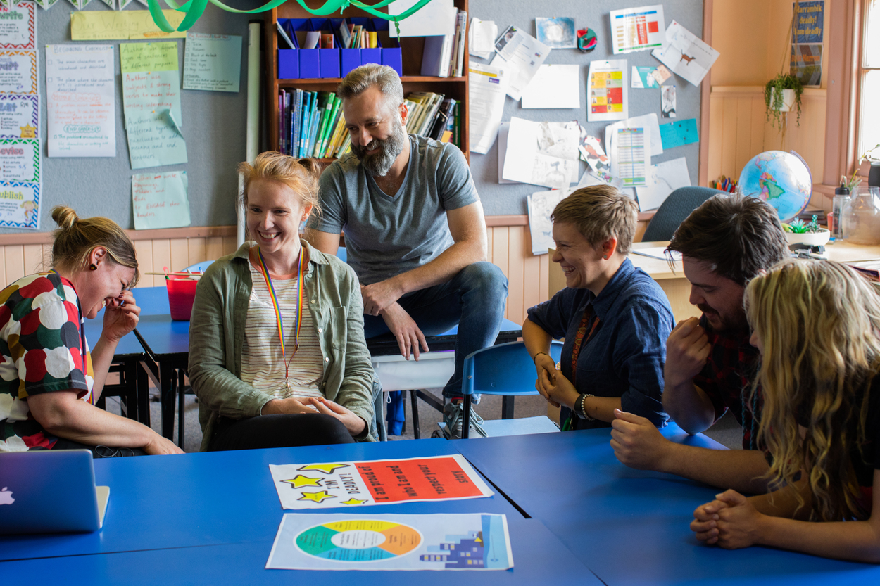 A group of educators sitting around a table, laughing