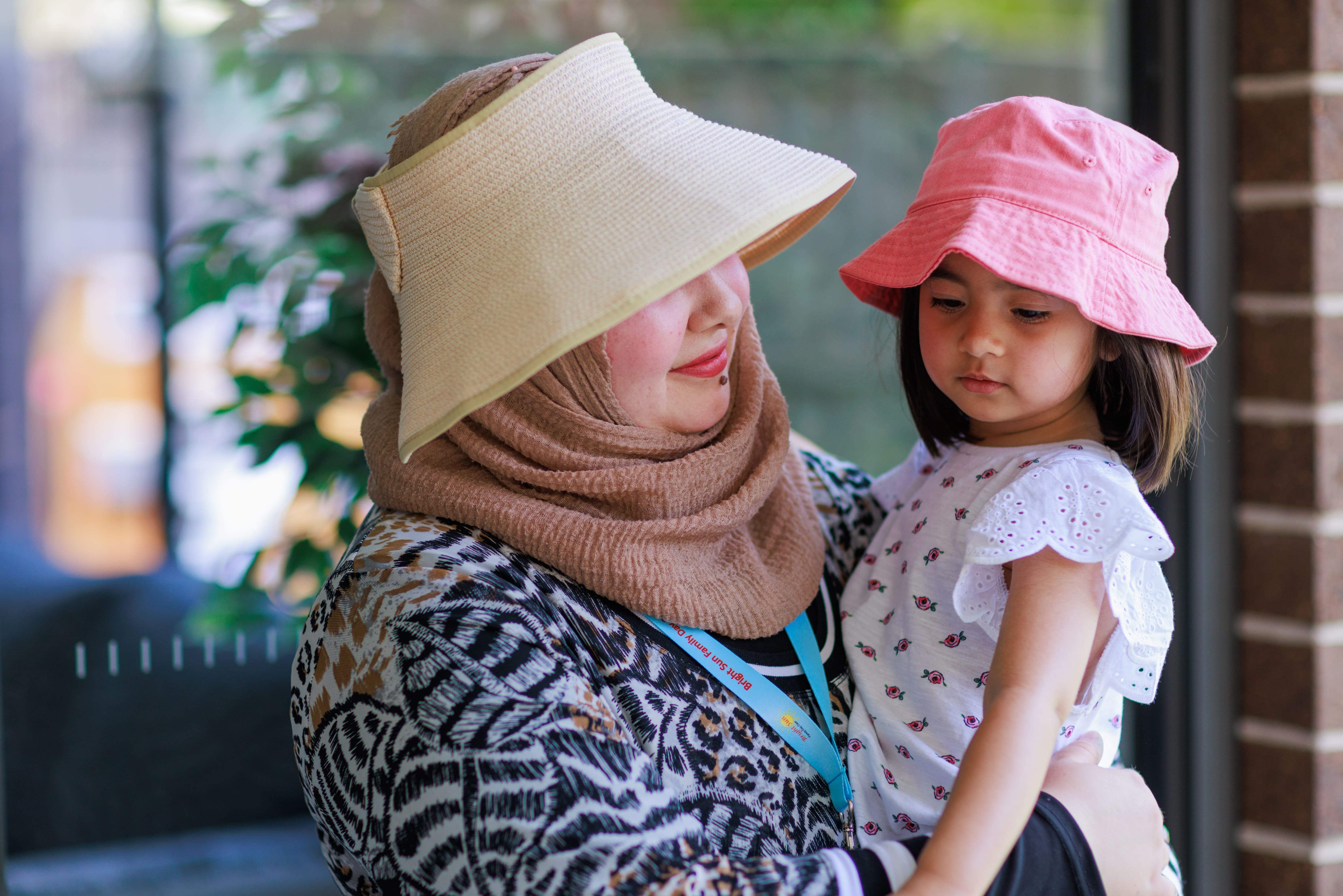 Educator carrying a young child in her arms